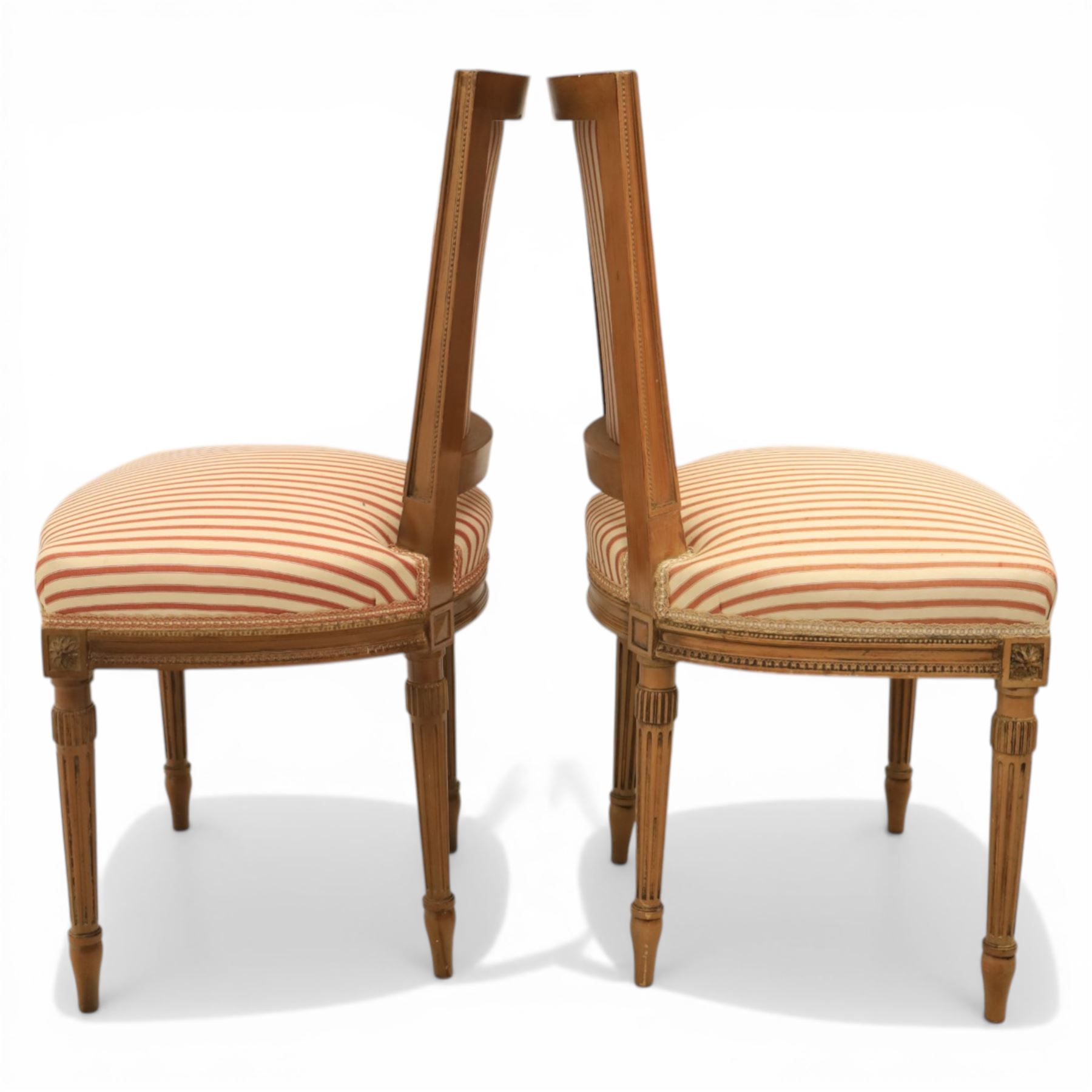 20th century Louis XVI style beech salon suite, comprising settee and four chairs, the settee with shaped rectangular back and upholstered arms over a shaped seat, the chairs with rectangular backs and overstuffed seats, each upholstered in striped fabric with close-nailed borders, upon fluted tapering supports headed by carved paterae, terminating in toupie feet, chairs H89cm W47cm