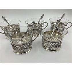 Early/mid 20th century Persian silver tea service, comprising circular serving tray, teapot, twin handled sucrier and cover, milk jug, five tea glasses with six silver holders, six tea spoons, and pair of sugar tongs, each profusely chased with foliate arabesque decoration, each bearing marks including 84 for 840 fineness, tray D40cm, teapot H16cm