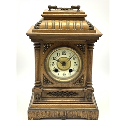 Late 19th century oak cased mantel clock, gadroon carved stepped pediment, circular dial with Arabic chapter ring flanked by two reeded half column pilasters, decorated with gilt metal mounts and ornate cast handle, twin train movement striking the hours and half on coil, H32cm