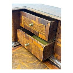 Late 19th century continental oak commode, serpentine fronted with parquetry and crossbanded decoration, the raised superstructure back fitted with a central bank of five recessed drawers flanked by concave drawers, above three full-width drawers with brass ring handles, raised on cabriole supports