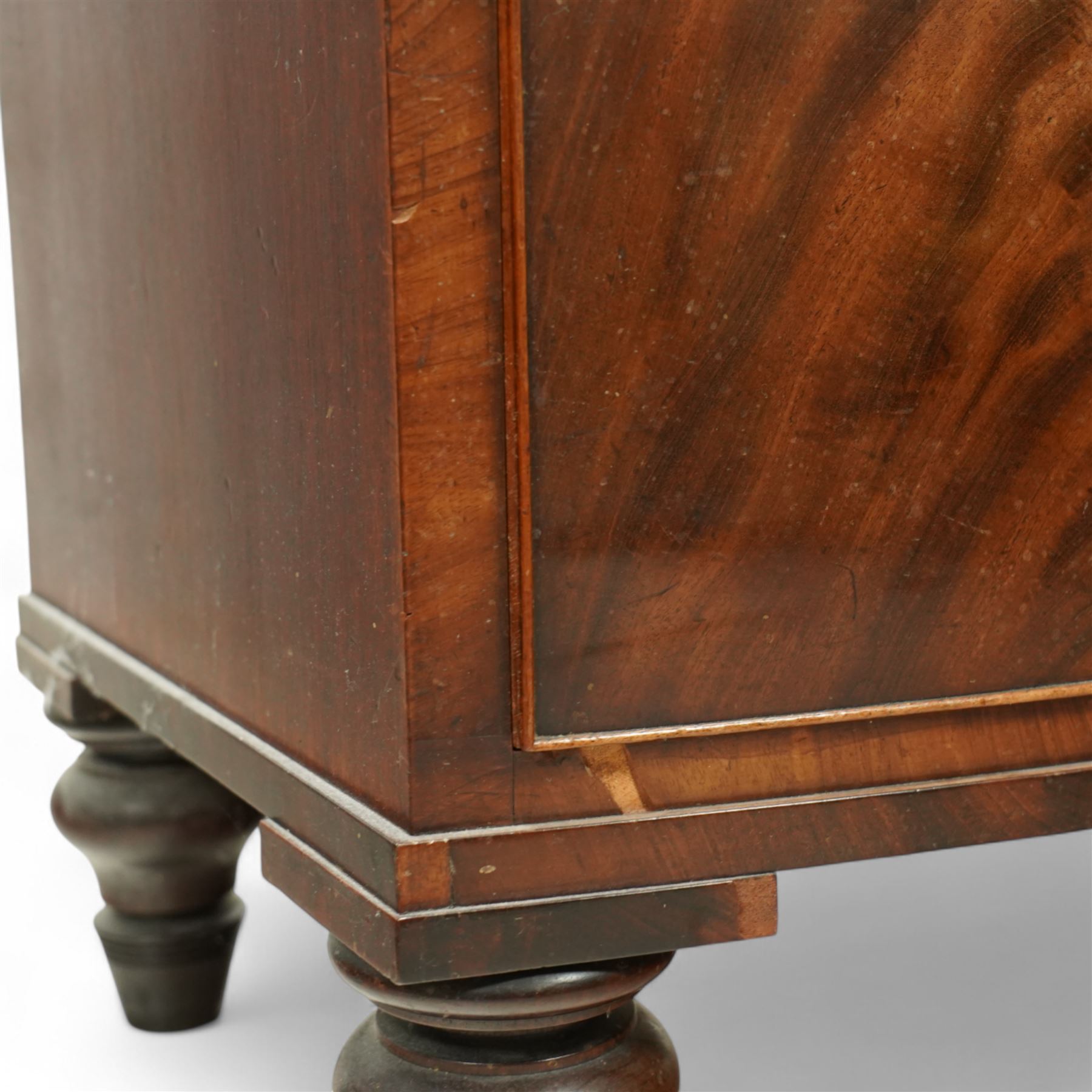 19th century mahogany chest of drawers, bow fronted form with two short over three long drawers, each veneered in matched flame mahogany, on turned feet