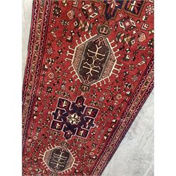 Persian Karajeh red ground runner, decorated with multiple stylised medallions and motifs