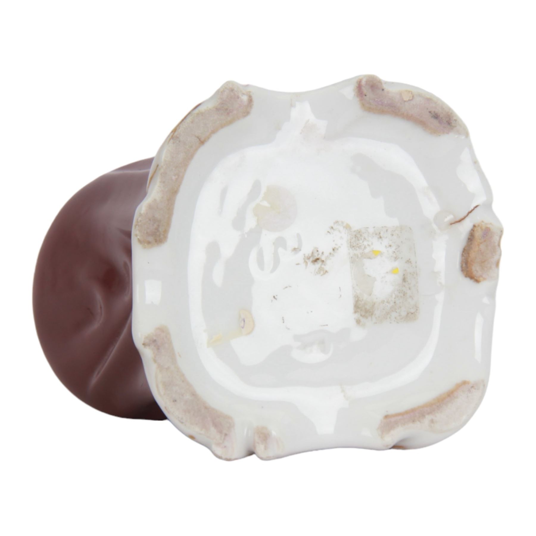 Mid 19th century French porcelain inkwell, possibly Jacob Petit, circa 1884, modelled as a anthropomorphic bear seated within an armchair, wearing cap, gown and slippers, reading a letter to a small cub holding a bunch of flowers, upon a shaped and scrolling base, impressed and incised marks beneath, H19cm
