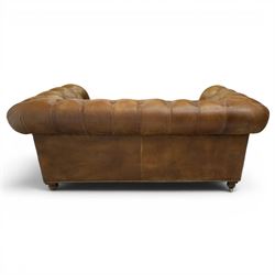 Timothy Oulton for HALO - Two seater brown leather chesterfield sofa, with button back and arms, with two loose cushions, raised on a dark stained supports terminating in castors 