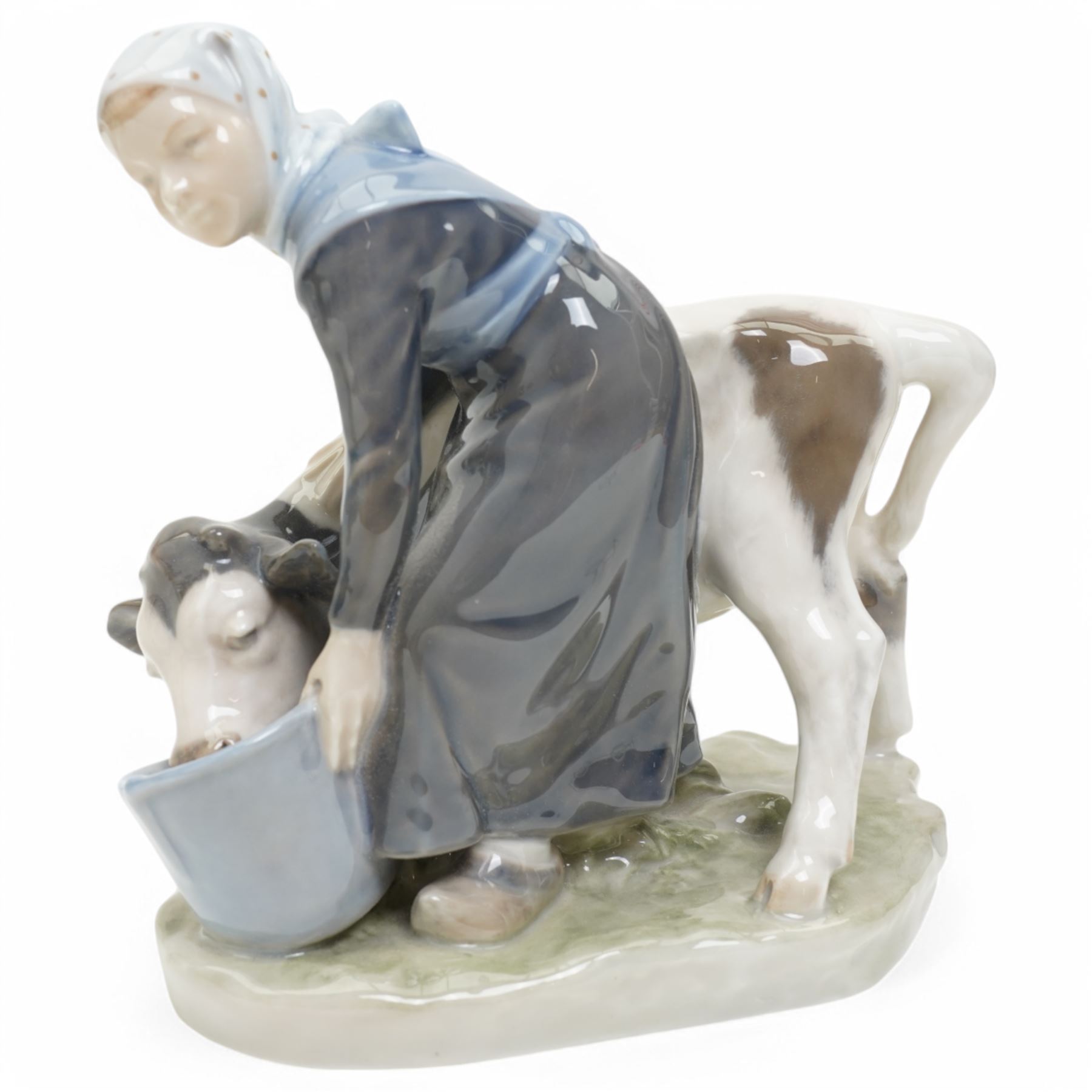 Three Royal Copenhagen figures, including Boy leading two Calves no. 1858, Boy with Calf no. 772, and Girl feeding Calf no. 779