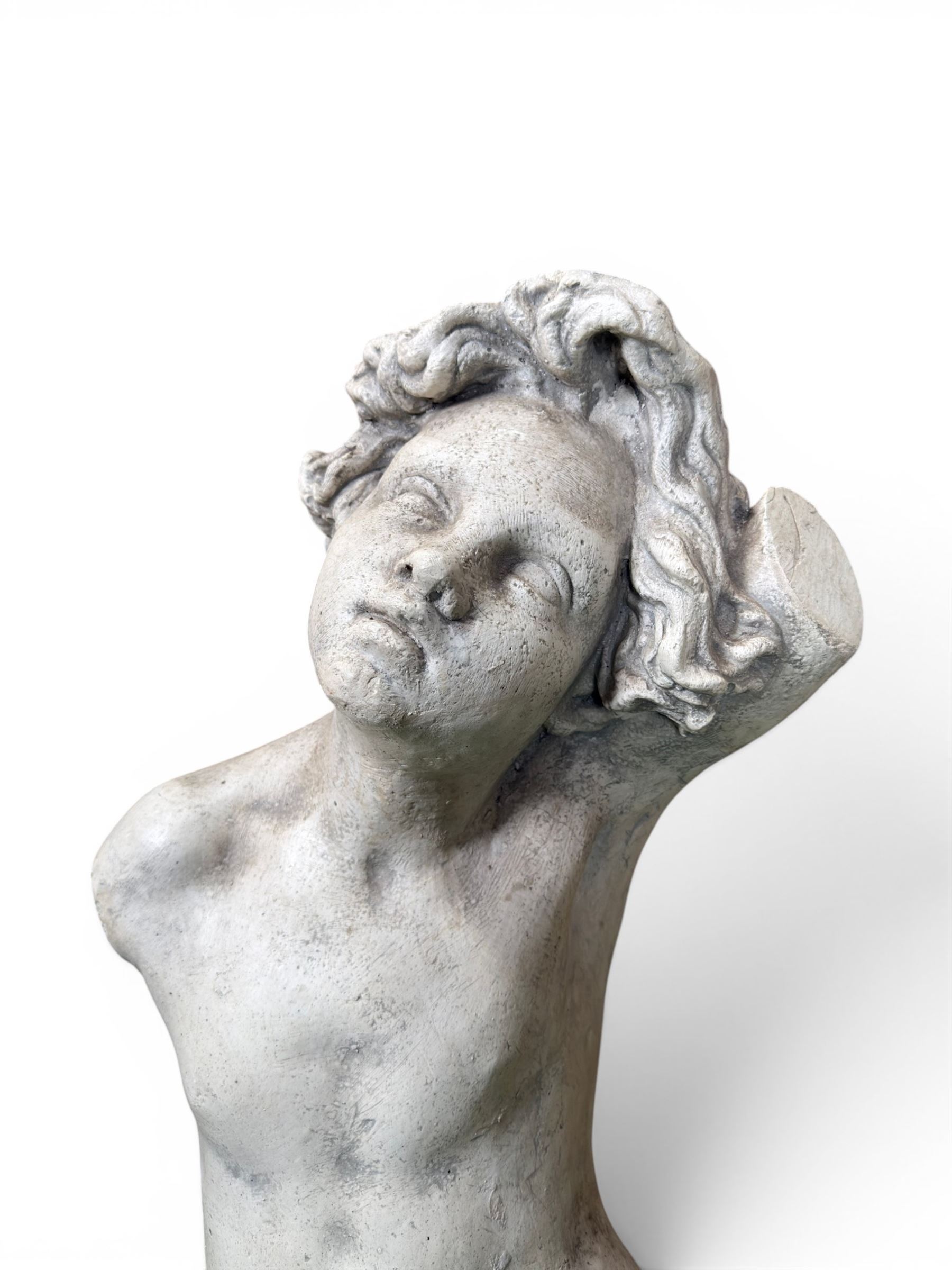 Early 20th century sculptured painted plaster figure of a boys torso, raised on 'stone' plinth