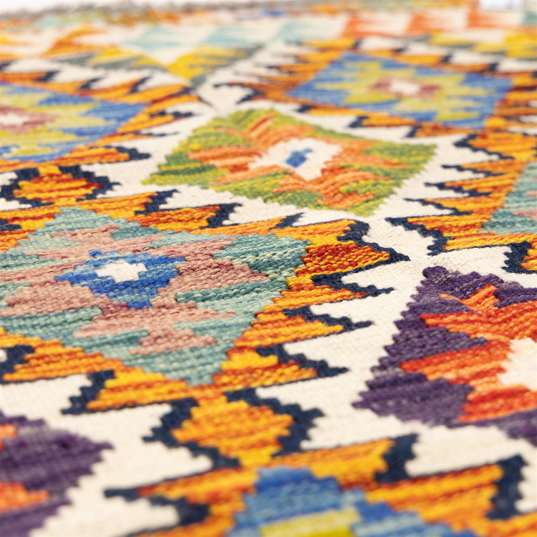 Two Chobi flatweave kilims with a repeating stepped diamond medallion design in live green, rust, teal, purple, and ivory, framed by chevron and geometric borders, 121x80cm & 87x60cm 