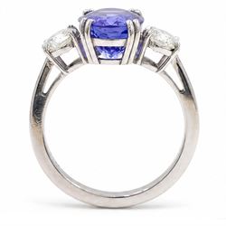 Platinum tanzanite and diamond three stone ring, single oval cut tanzanite of approx 3.55 carat, with a round brilliant cut diamond set either side, total diamond weight approx 0.80 carat