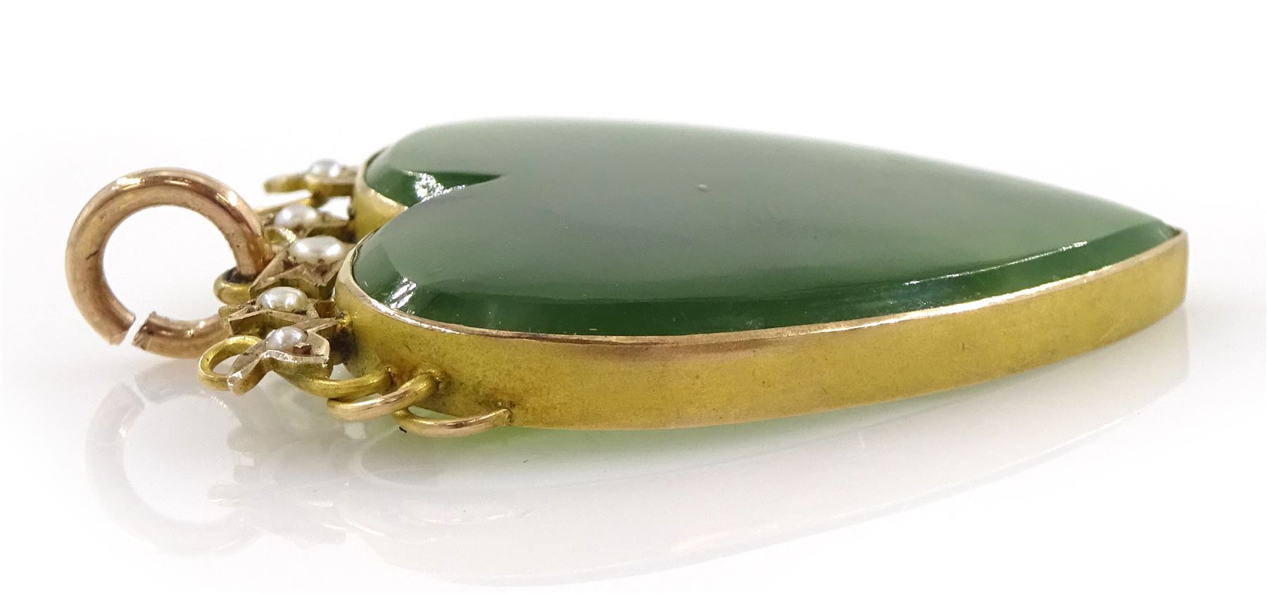 Early 20th century gold mounted heart shaped jade pendant, with gold leaf design top set with seed pearls, stamped 9ct