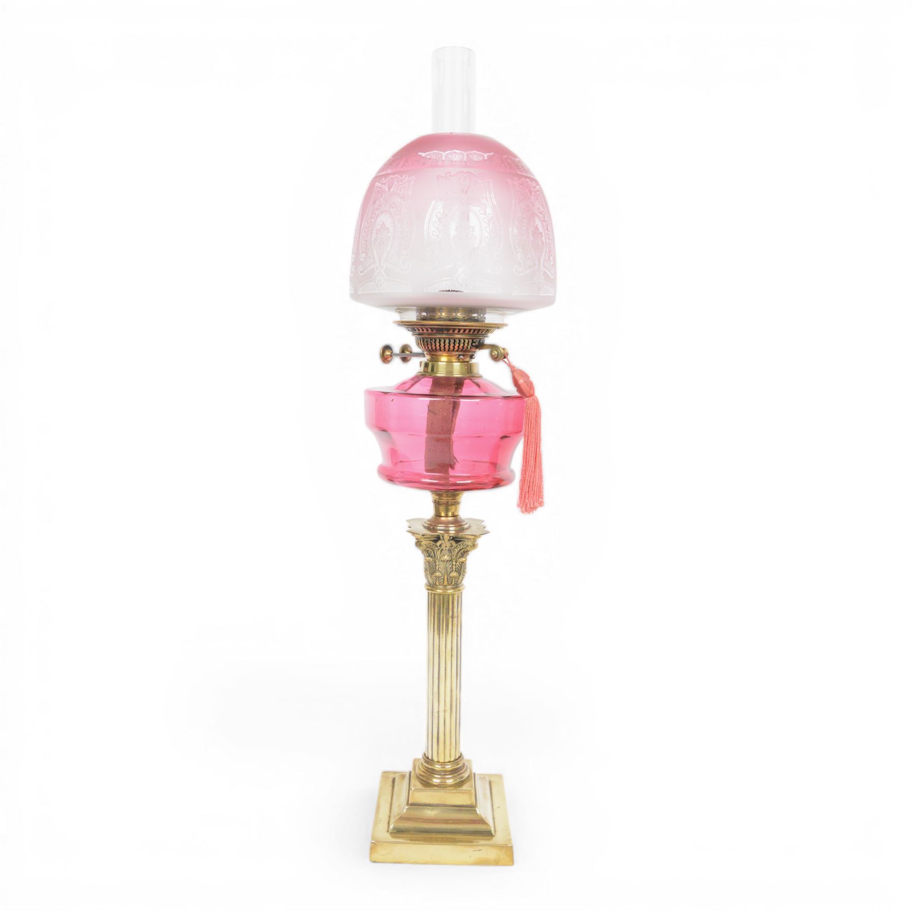 Victorian brass oil lamp, the Corinthian column supporting a cranberry glass burner and opaque etched cranberry glass shade and clear glass chimney, overall H77cm