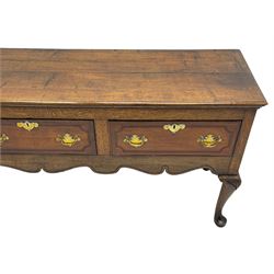 18th century and later oak dresser base, the rectangular top with a moulded edge, fitted with three mahogany banded and cock-beaded drawers, the facias with brass handles and escutcheons, over a shaped apron with carved rail, raised on cabriole supports with foliate carved knees and pad feet