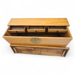 Burmese hardwood and brass inlaid marriage chest, the hinged top enclosing a fitted interior with small drawers, the front decorated with a circular brass medallion, raised on a plinth base