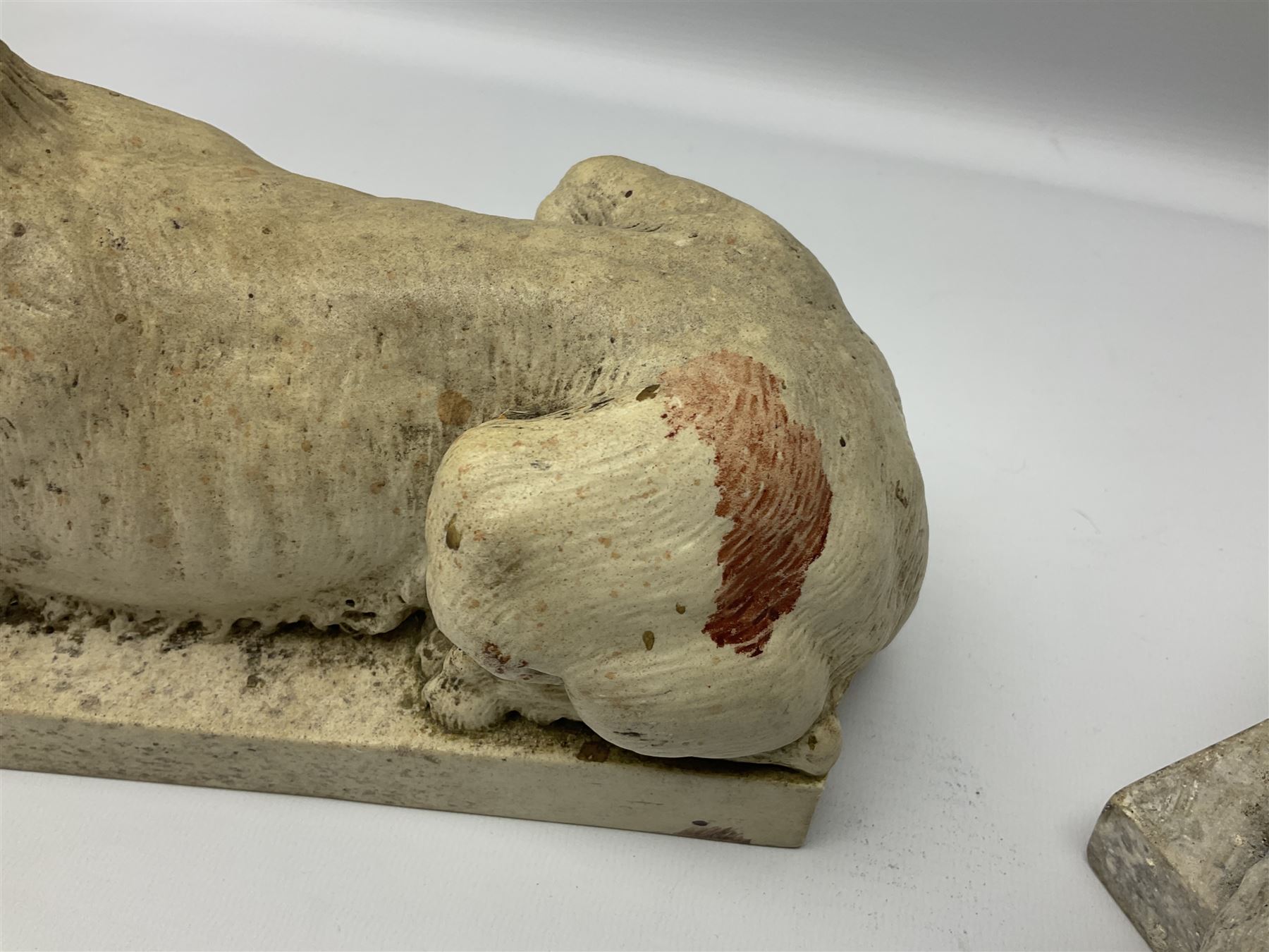 Two early 20th century reconstituted stone Grand Tour or Chatsworth House type lions after Antonio Canova, each modelled in recumbent pose upon a rectangular plinth, signed to plinth Dilettanti, each approximately L31cm