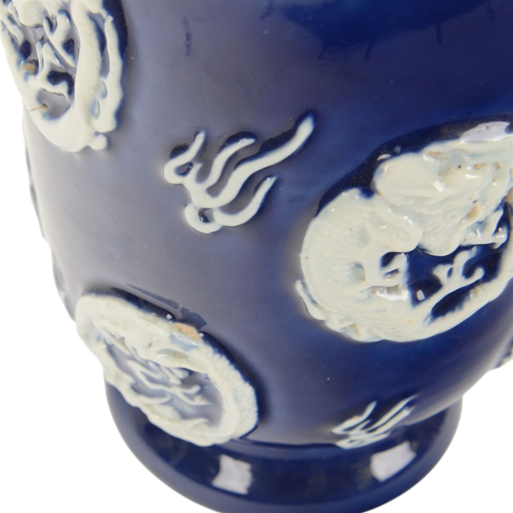 Chinses twin handled blue and white vase, decorated in relief with dragons amongst clouds upon a blue ground, H58cm 