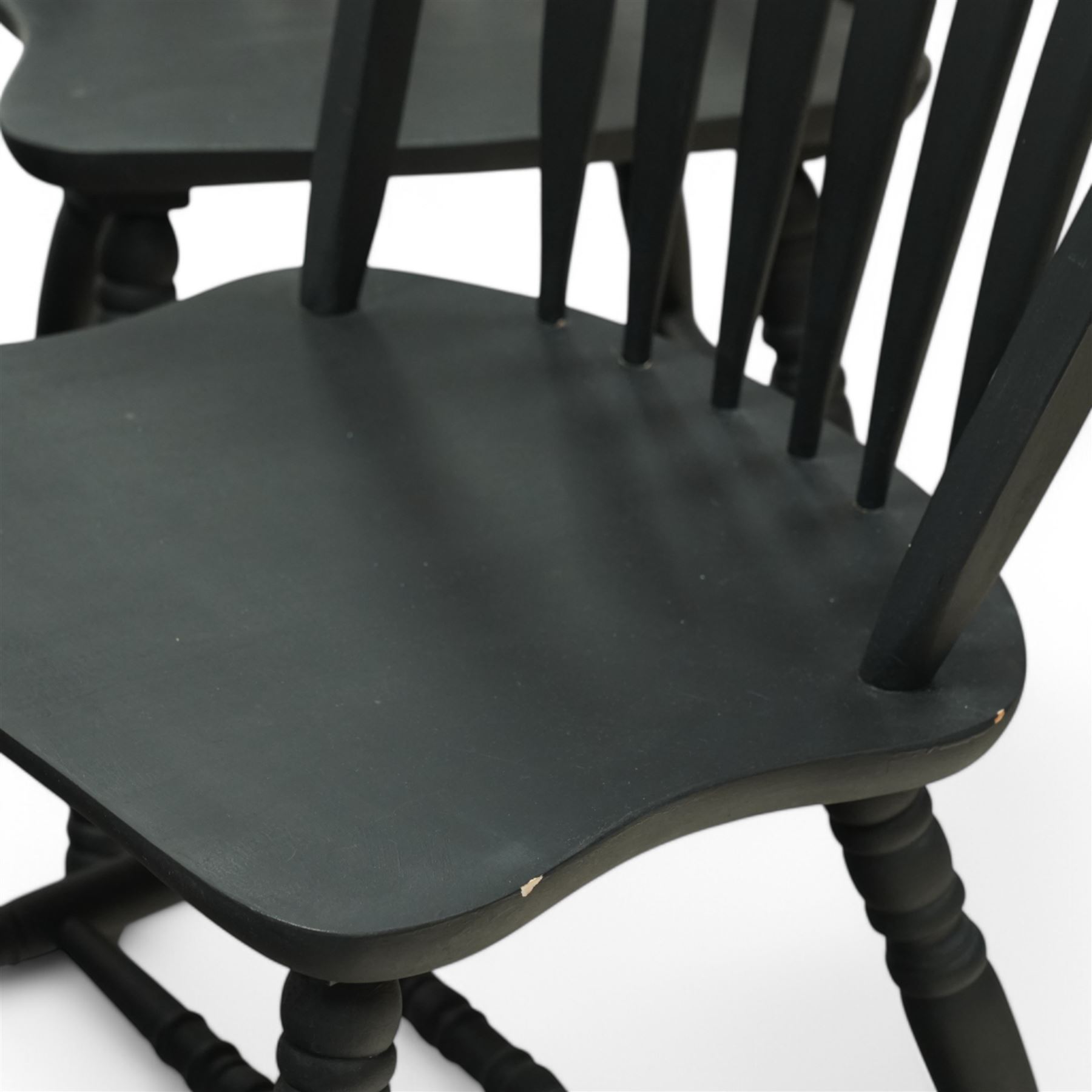 Contemporary country style pine and painted dining table and four chairs, the rectangular plank top with exposed knots and pegged detailing over black painted turned legs, the four Windsor style chairs with shaped seats, spindle splats and turned stretchers, also painted black