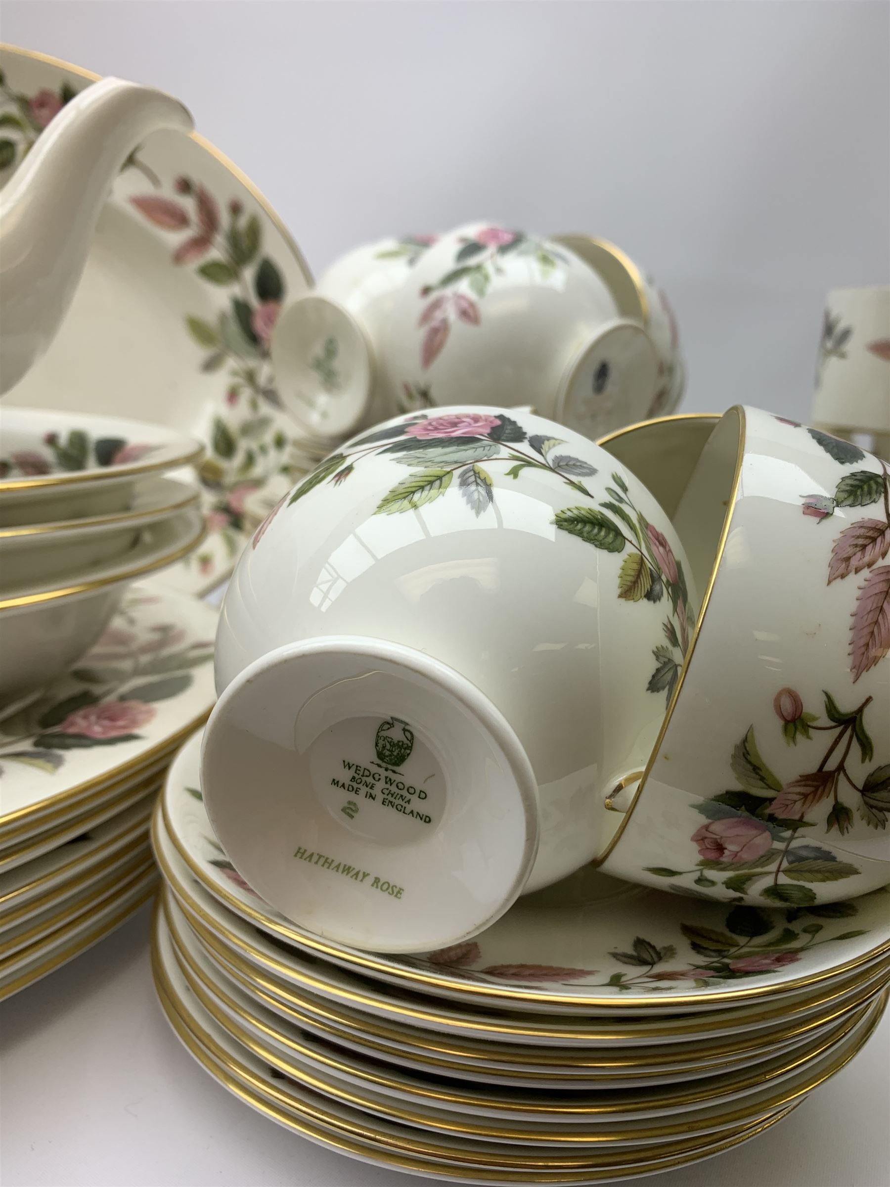 Wedgwood Hathaway Rose pattern dinner and tea wares, comprising eight dinner plates, eight salad plates, eight dessert plates, six side plates, six soup bowls and six saucers, sauce boat and stand, three oval serving dishes, oval serving platter, teapot, coffee pot, eight tea cups and eight saucers, eight coffee cans and eight saucers, two open sucriers, milk jug, cream jug, two ashtrays, and a lidded box and cover. 