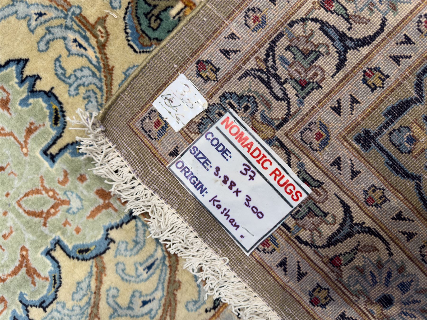 Central Persian Kashan hand-knotted carpet, ivory field with scrolling vines, palmettes, and rosettes around a cusped medallion with pendants and spandrels within a blue ground border of palmettes and flowerheads, 388cm x 300cm