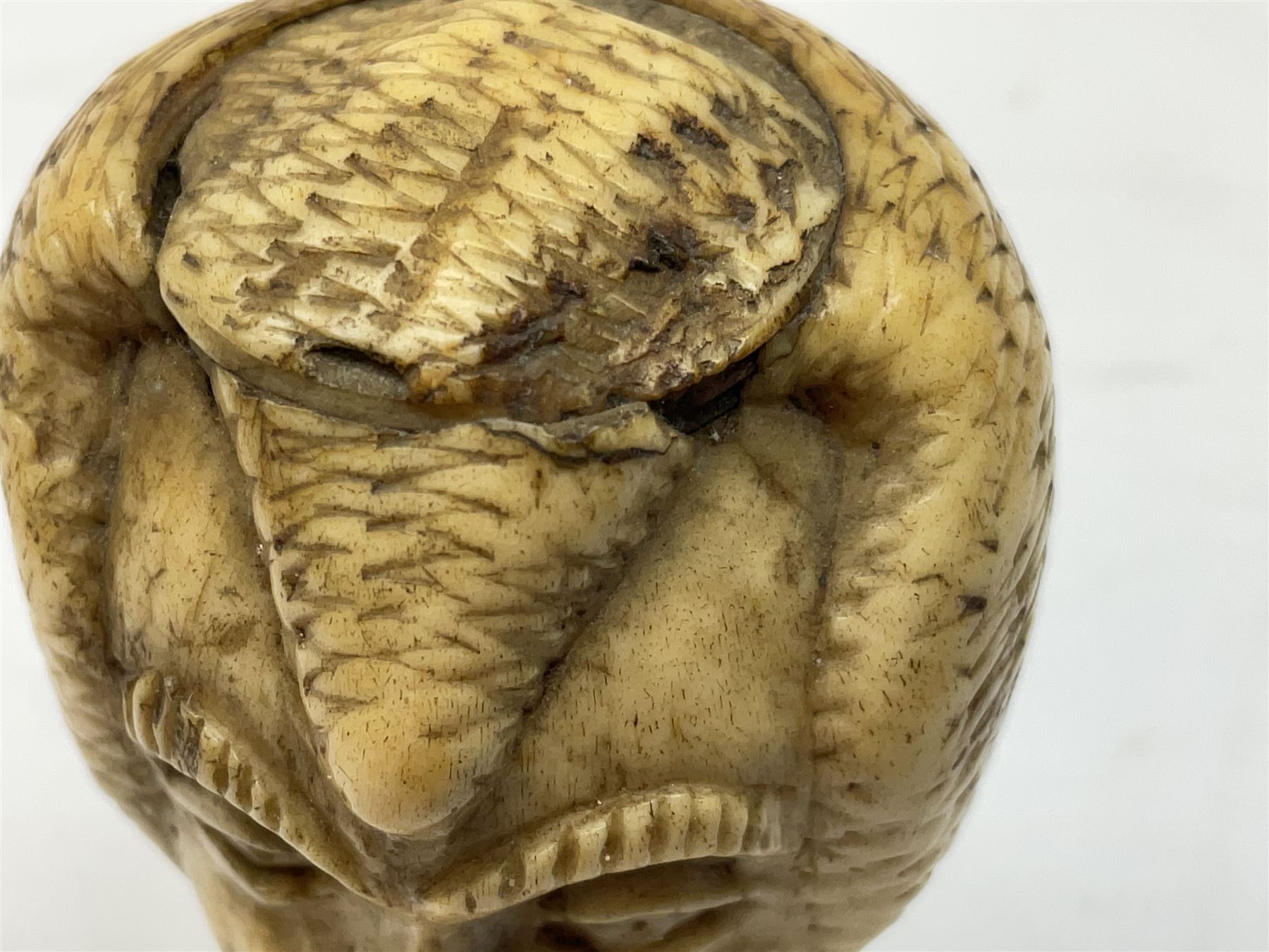 19th century carved ivory walking cane handle, modelled as the head of a greyhound with inset glass eyes, together with a further 19th century ivory example, modelled as a caricature of a gentleman's head, (2)