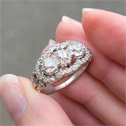 Late 19th / early 20th century platinum diamond ring, three old cut diamonds, in an openwork setting surrounded by further old cut diamonds, with pierced design shoulders, principal three diamonds total weight approx 1.45 carat, in a velvet and silk lined box by Selfridges