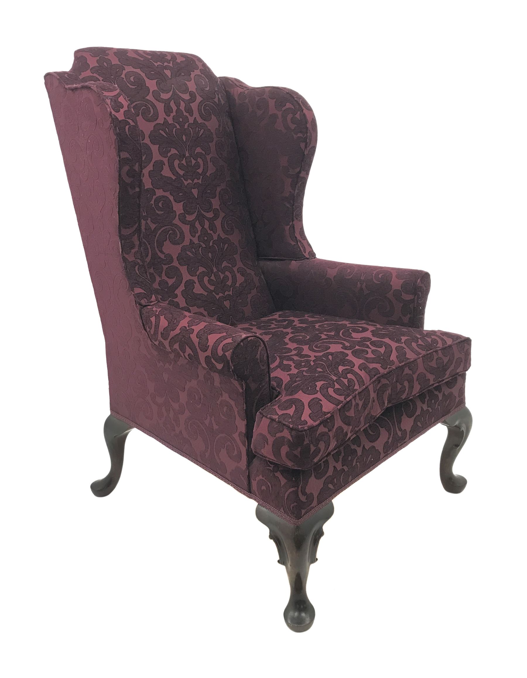 Traditional Queen Anne style high wingback armchair upholstered in purple fabric with raised scrolling pattern, on cabriole feet