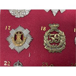 Eighteen glengarry and cap badges including Argyll & Sutherland, Black Watch, Kings Own Scottish Borderers, Royal Scots, Royal Tank Corps, Royal Armoured Corps, Royal Marines, East Lancashire, Hampshire Yeomanry Carabiniers etc; mounted on a board for display