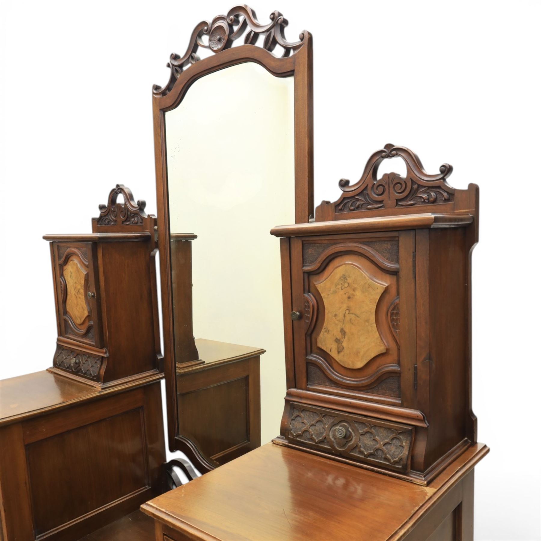 Edwardian figured walnut dressing chest, with central tilting mirror with pierced fret work, flanked by cabinet with figured walnut panelled door above a trinket drawer, with four short over a long long drawer, raised on a plinth base with castors 