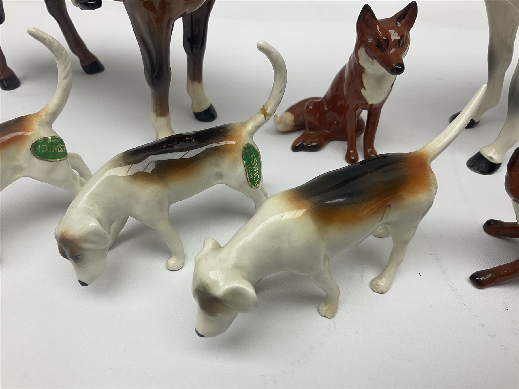 Beswick hunting group, comprising huntswoman on dappled grey horse no 1730, huntsman on bay horse no 1501, two fox figures no 1440 and 1748, and four fox hounds, all with printed marks beneath (8)