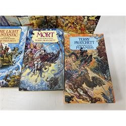 Collection of books by Terry Pratchett, of mostly Discworld interest, to include hardback edition of Going Postal, and further books such as Men at Arms, Sourcery, Small Gods etc 