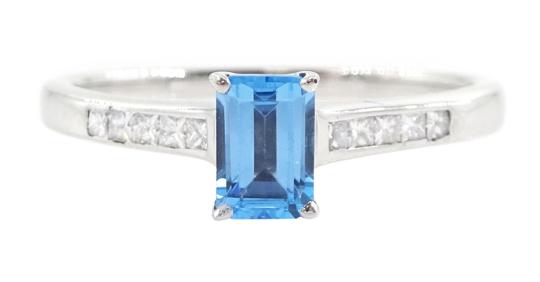 18ct white gold blue topaz and diamond ring, the single emerald cut topaz of approx 0.65 carat, each shoulder set with five, channel set princess cut diamonds