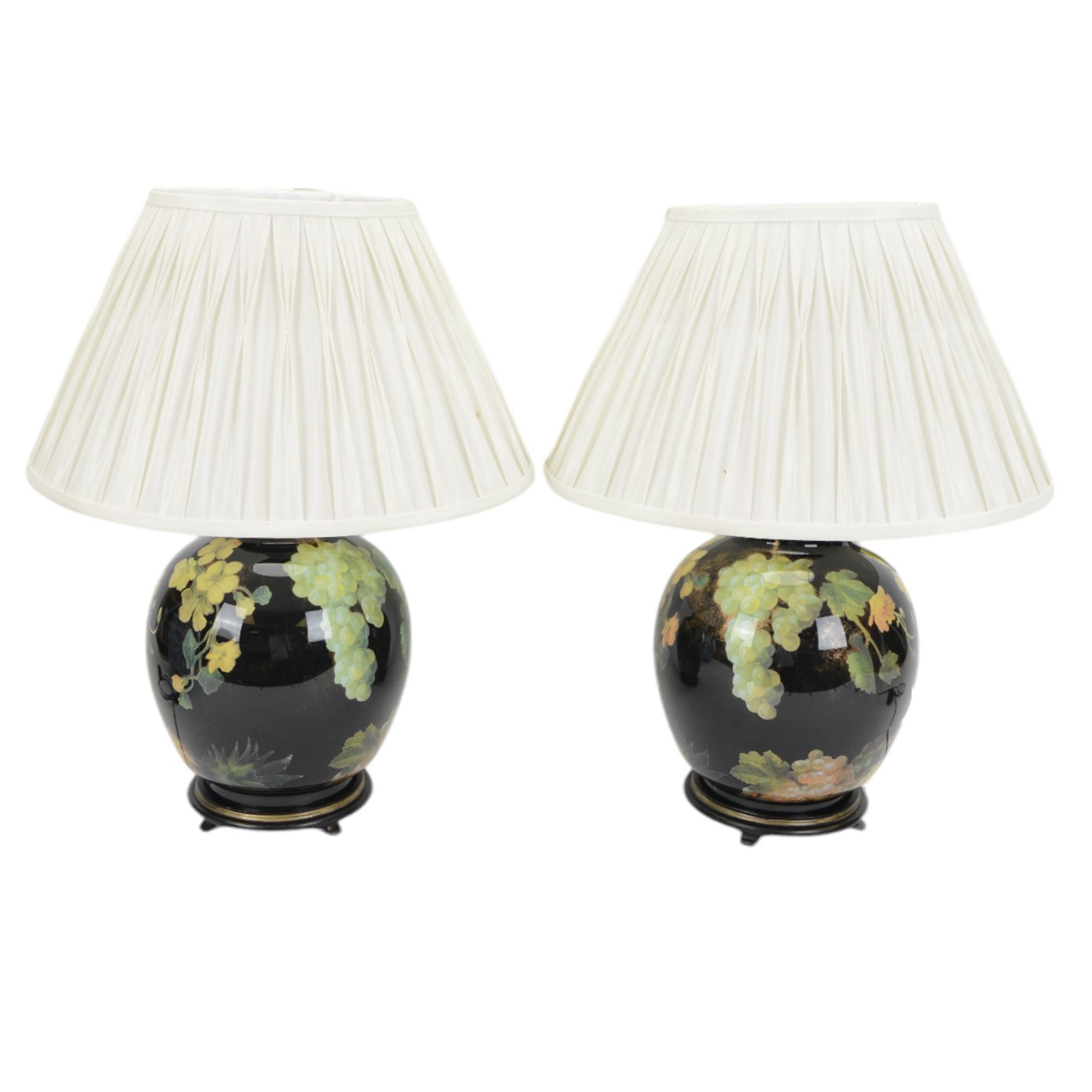 Pair of Jenny Worrall table lamps, of ovoid form, the glass body decorated with fruit and trailing flowers upon a black ground with gilt flecks, with pleated cream lampshades, including shades H65cm