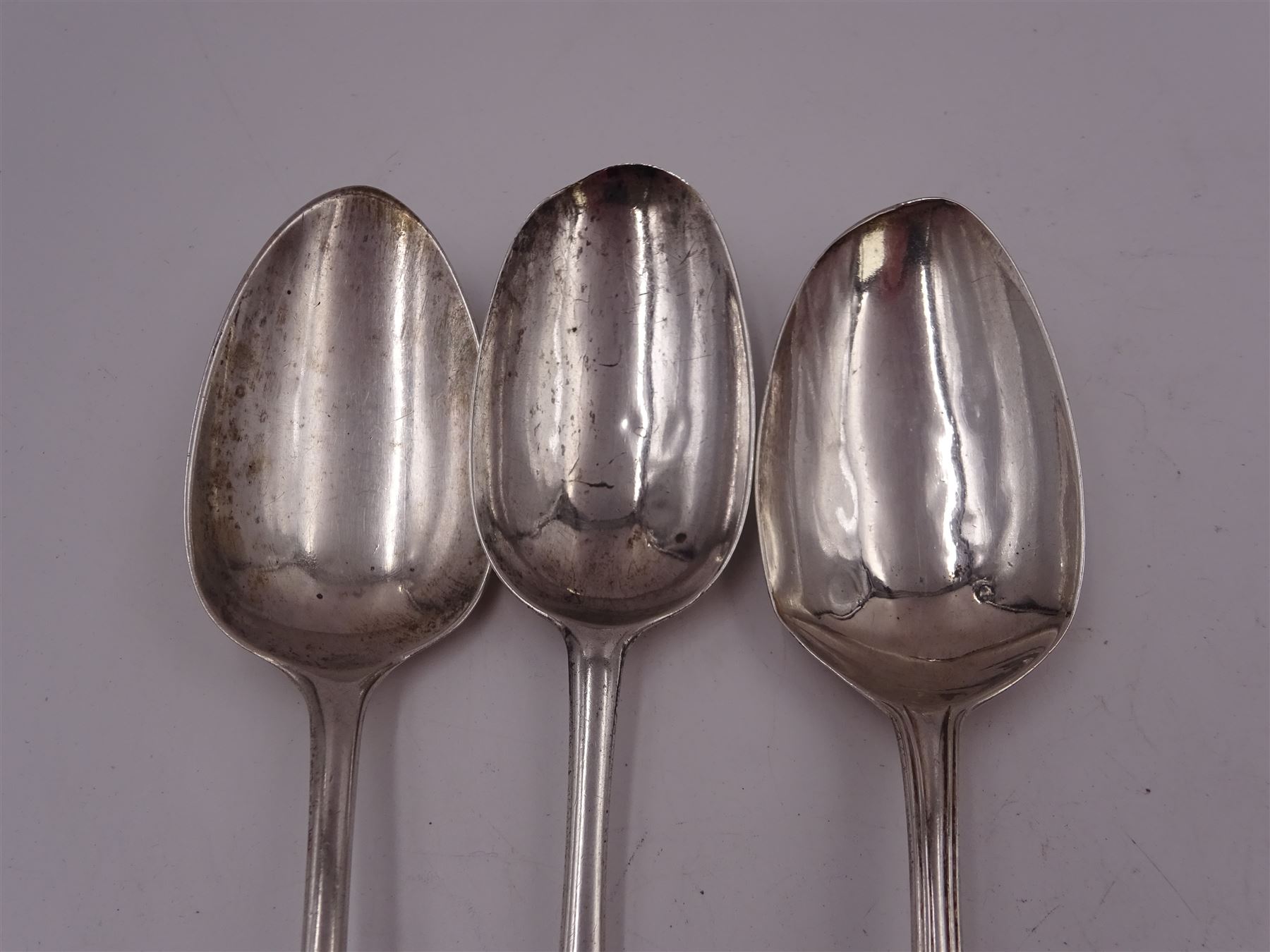 George II silver Hanoverian pattern table spoon, with rattail bowl and engraved with initials BV to terminal verso, hallmarked London 1730, makers mark IH or IK, possible Jeremiah King or John Hopkins, together with two George III silver Old English pattern table spoons, the first example with reed border, hallmarked Stephen Adams II, London 1787, the second example hallmarked London 1800, maker's mark indistinct