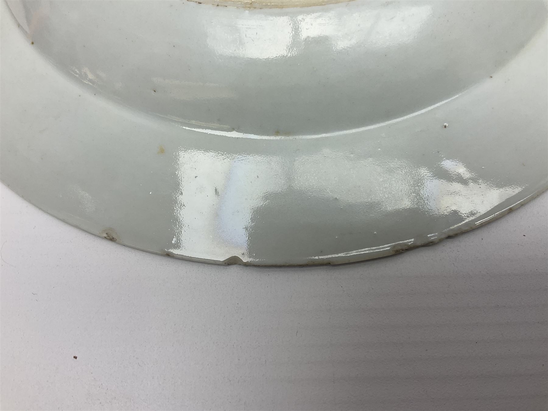 Three 18th century Chinese Famille Rose plates, the first example enamelled with blossoming peonies, rockwork and fence, the other two examples of similar design, decorated with blossoming peonies and sprigs within shaped inner borders, each approximately D23cm