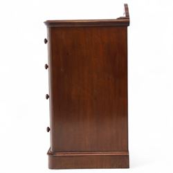 Pair of tall Victorian mahogany bedside chests, of narrow upright form, rectangular top with moulded edge, the back with raised pierced fretwork gallery, above four graduated drawers with knob handles, raised on a plinth base 