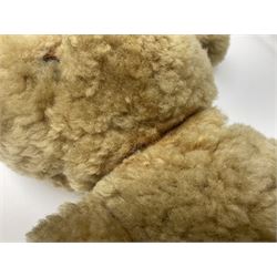 1950s sheepskin plush covered teddy bear with musical movement, the revolving head with applied eyes, leather nose and stitched mouth, jointed limbs with leather pads H50cm