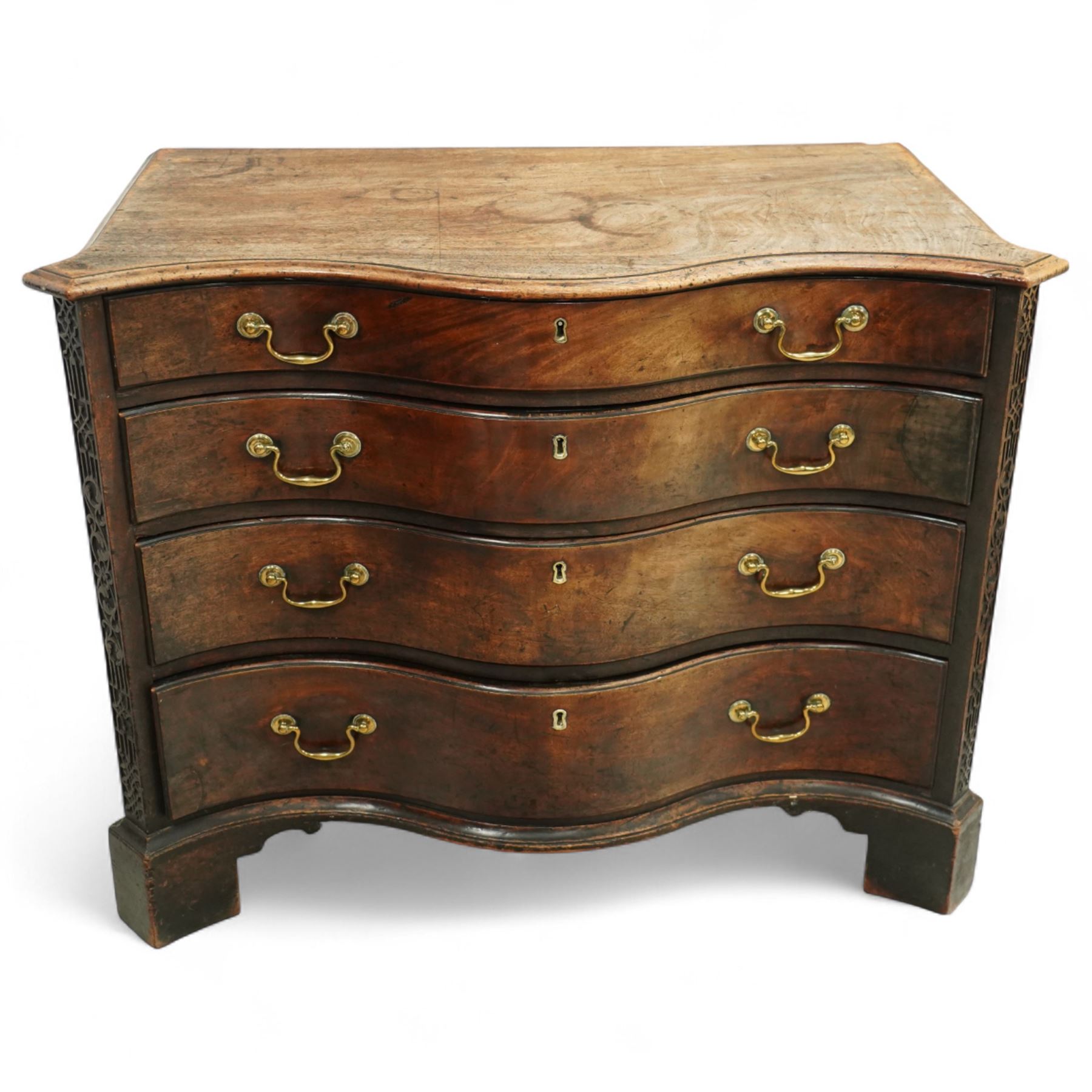 George III Chippendale period mahogany serpentine-fronted chest, shaped top with moulded edge over a deep serpentine outline with four graduated drawers, the canted corners decorated with blind-fretwork geometric decoration, fitted with brass swan-neck handles, lower moulded edge on bracket feet, circa 1760-1770