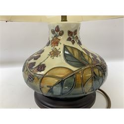 Moorcroft table lamp of squat baluster form, decorated in the Autumn Blackberry, with Moorcroft cream fabric shade with gold, green and red piping, overall H38cm