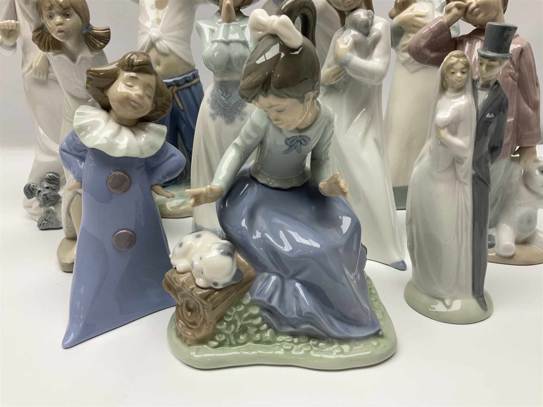 Eleven Nao figures to include Cowboy, Girl with Puppy, Clown, Girl in hat etc 