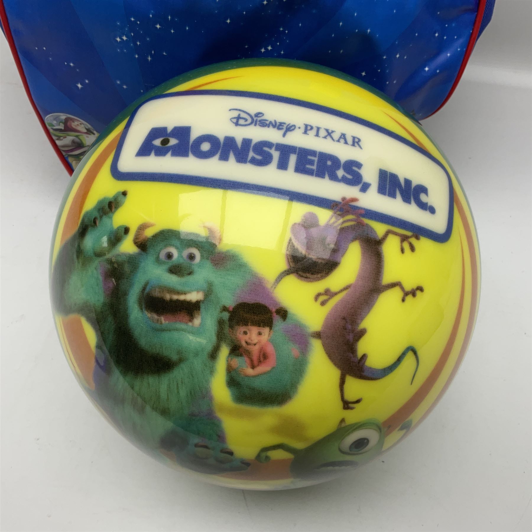 Two The Simpsons 'The Bowling Club' tenpin bowling balls, the first an undrilled example depicting Bart Simpson on a green ground, the second a drilled example depicting the Simpsons family on an orange ground, both in Simpsons The Bowling Club bags, together with a Disney Monsters, Inc. tenpin bowling ball, in matching bag and a Maxim tenpin bowling ball