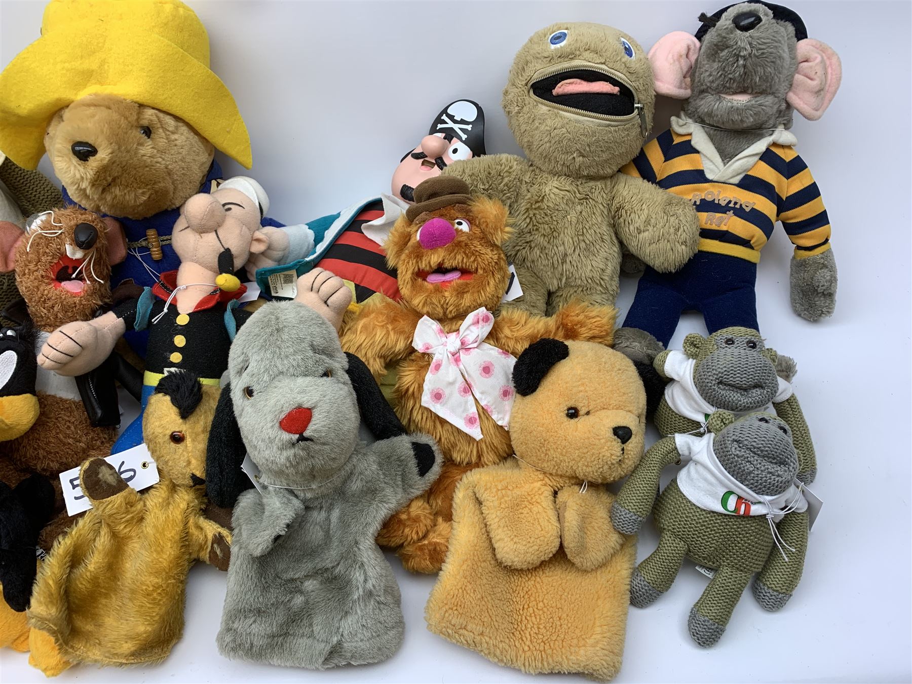 Twenty-one TV and film related and promotional soft toys including Sooty and Sweep hand puppets, Captain Pugwash, Muppets, Yogi Bear, Popeye, Paddington Bear, Zippy, Roland Rat etc