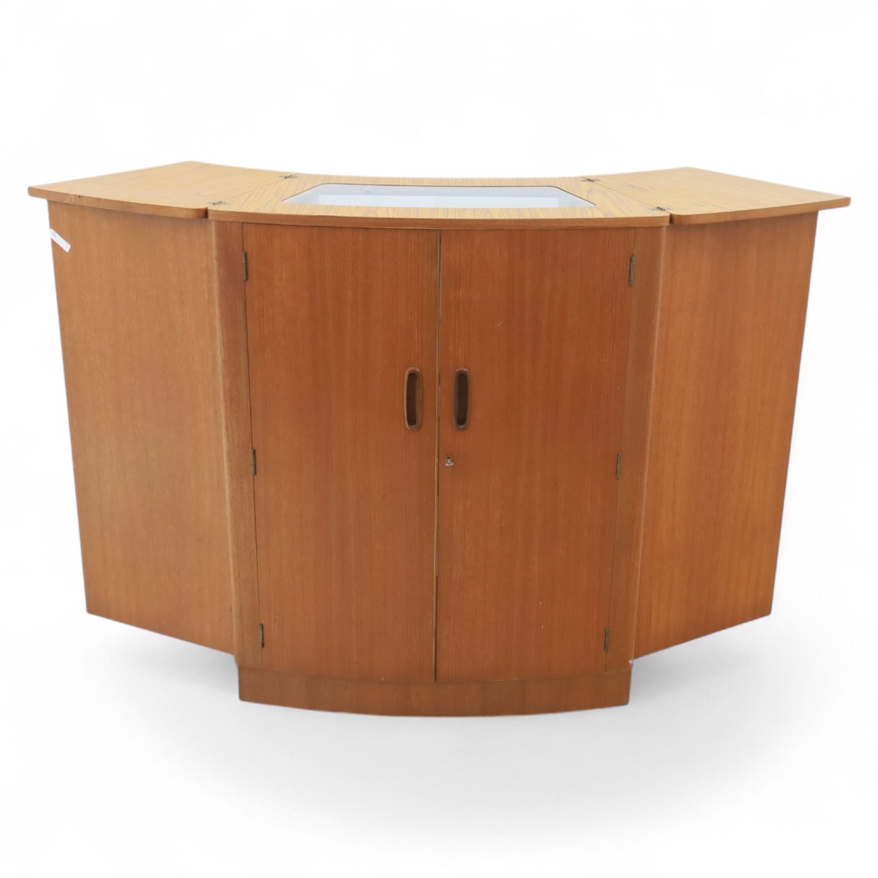 Turnbridge of London - Mid 20th century teak cocktail cabinet, with fold out top extending to 160cm, with twin doors revealing a shelved interior, the back with sliding glazed doors, raised on a recessed plinth base with castors