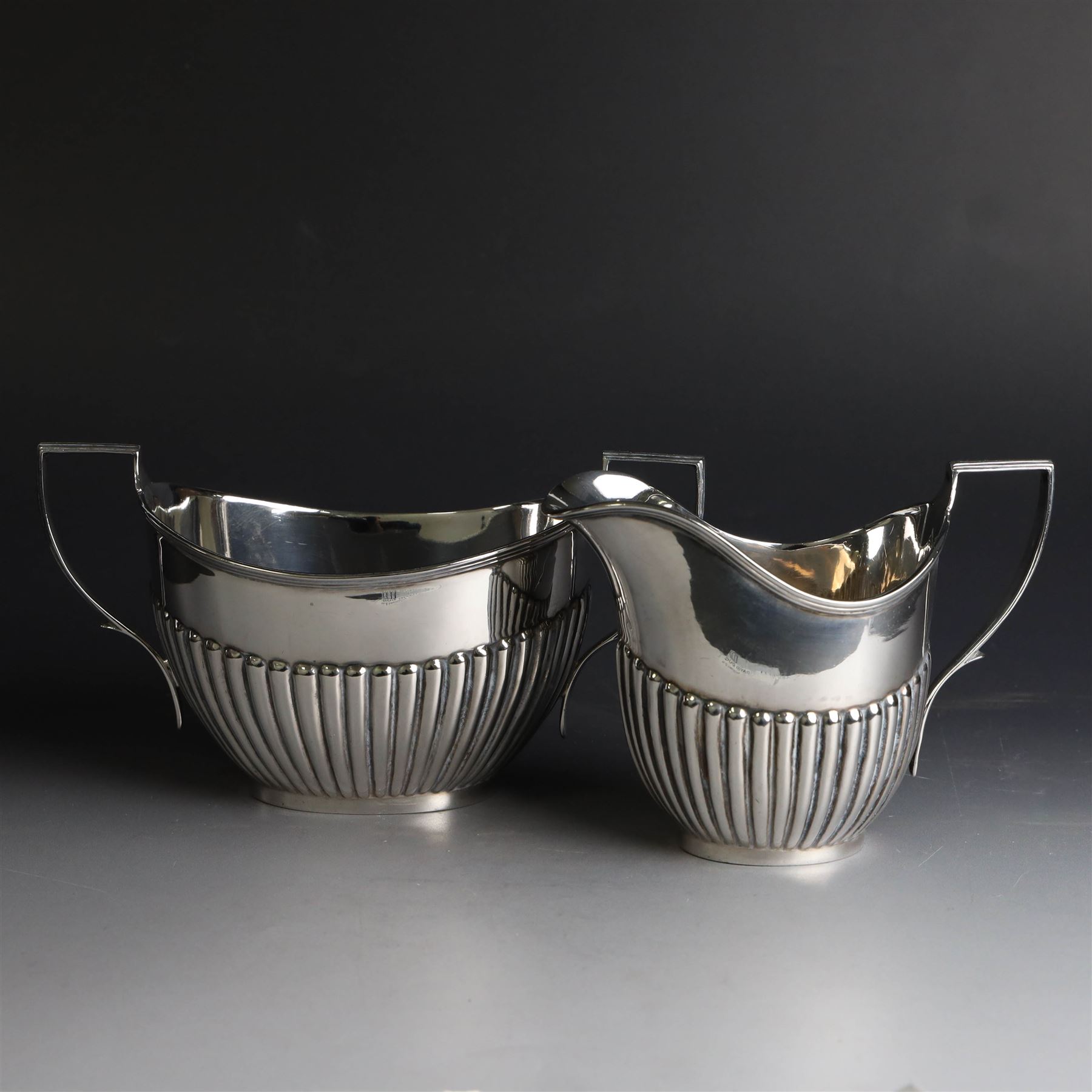 1920s silver three piece tea service, comprising teapot, twin handled open sucrier and milk jug, each of oval part fluted form, the teapot with Bakelite type handle and finial, hallmarked Cooper Brothers & Sons Ltd, Sheffield 1922
