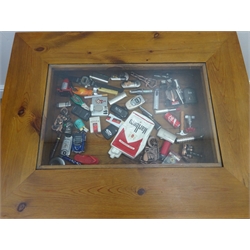  Collection of novelty lighters including Marlboro in glass topped pine display table, W76cm, D48cm, H58cm   