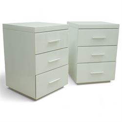 Pair of contemporary white and glass bedside chests, with square top over three drawers with integrated handles, plain sides and plinth bases