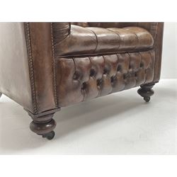 Large pair of Country House chesterfield club armchairs of generous proportions, upholstered in deeply buttoned brown leather, turned front supports with castors, rear splayed supports