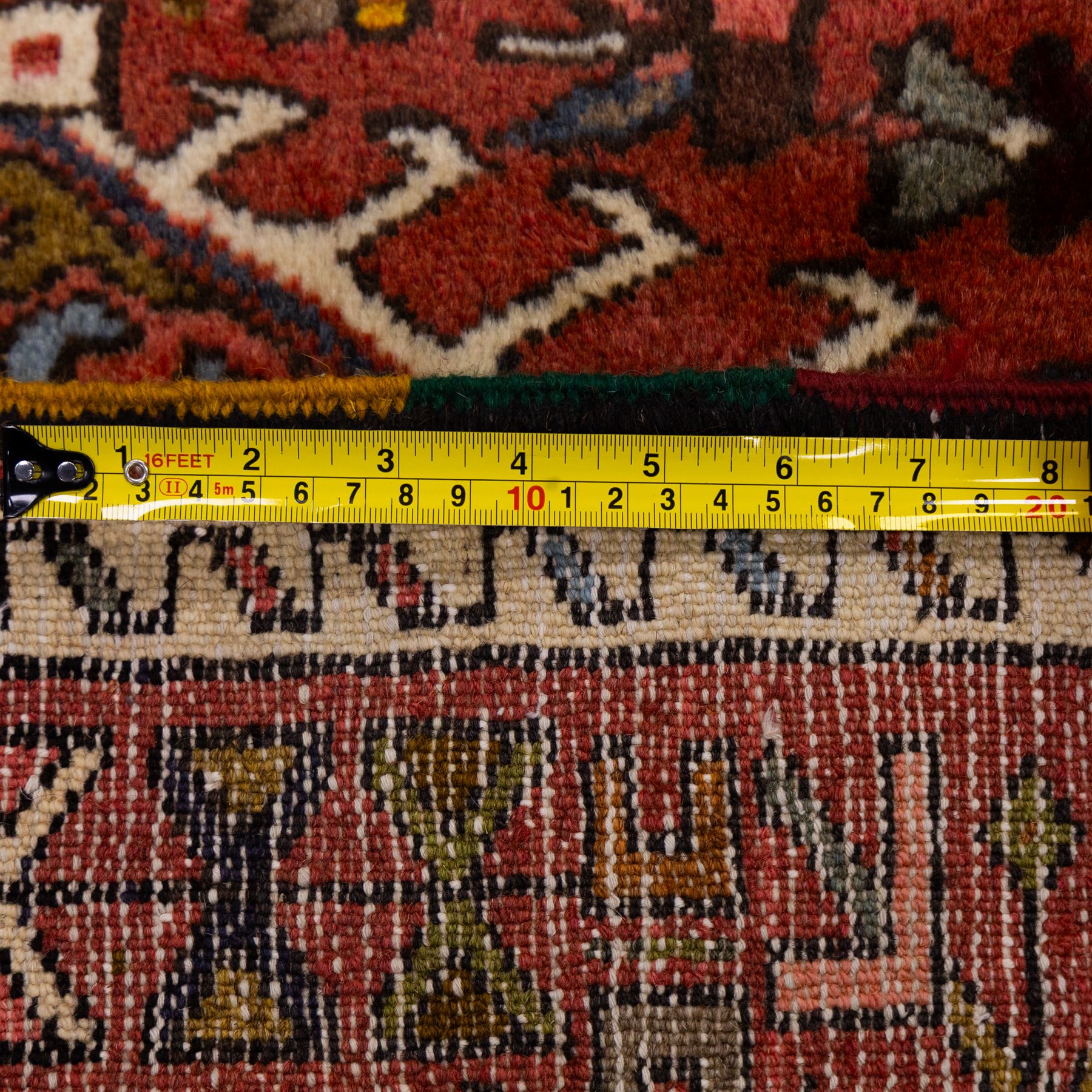 North West Persian Heriz hand-knotted runner, terracotta field decorated with a series of large angular medallions with stylized geometric motifs, surrounded stepped devices, and stylized trees within narrow geometric border, and polychromed edge, cotton fringe ends 