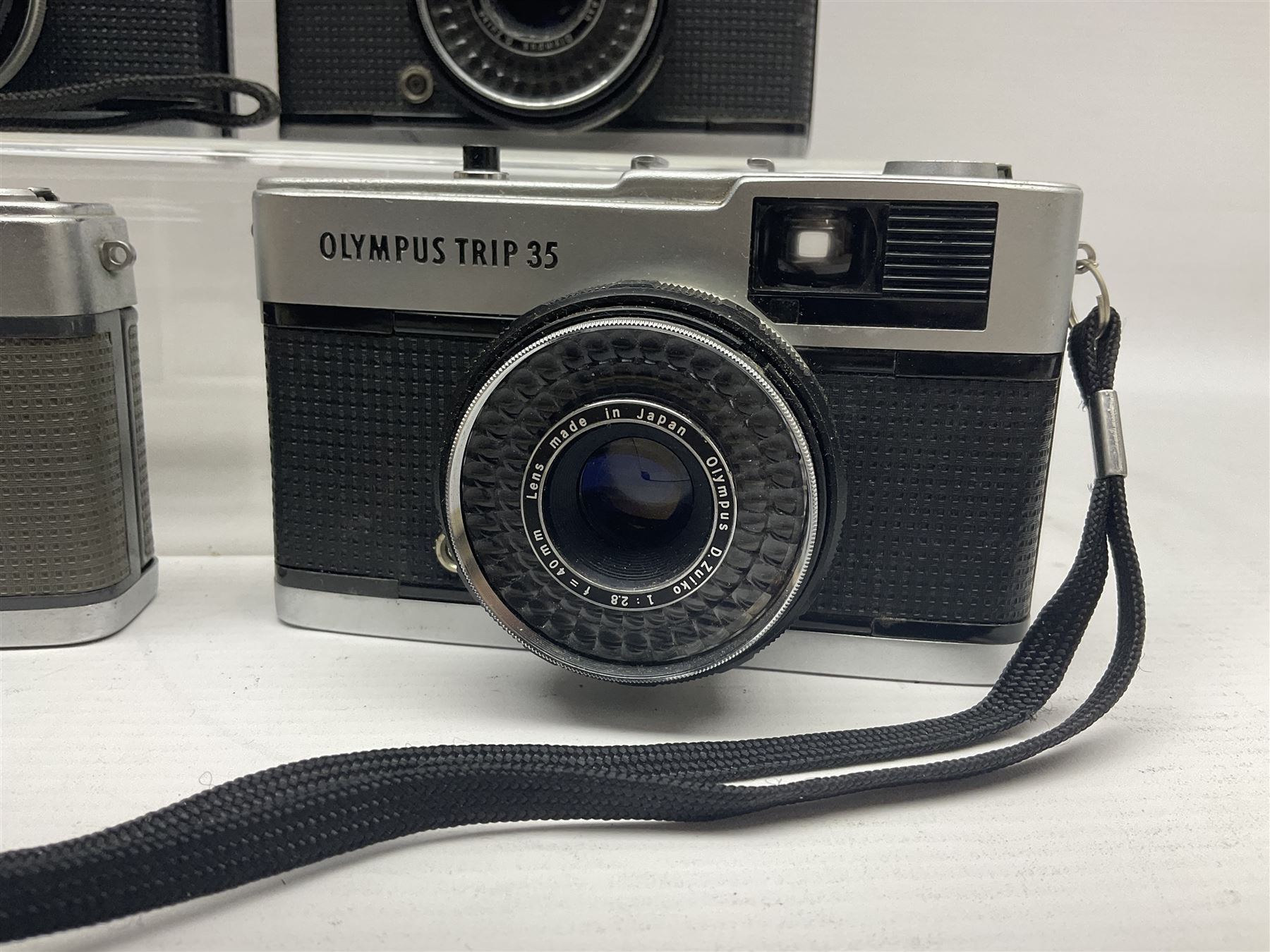 Olympus Pen-EE camera, serial no 415299, with Olympus D.Zuiko 1:3.5 f=2.8cm lens, together with four Olympus Trip 35 cameras, serial nos 4759245, 4257589, 1847727 and 5387611, each with Olympus D. Zuiko 1:28 f=40mm lenses