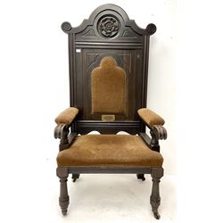 Late 19th century oak throne chair, shaped cresting rail with carved Yorkshire Rose, upholstered splat, arms and seat, turned supports on castors 