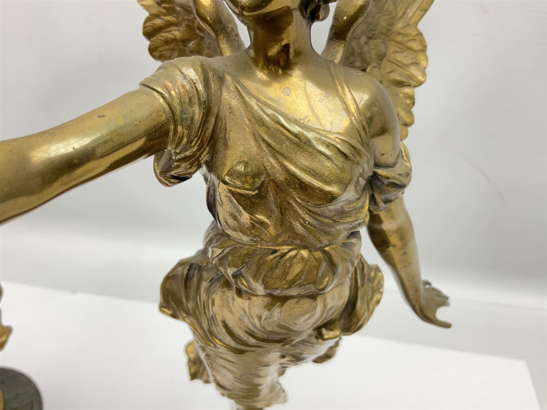 After Oswald Schimmelpfennig (German, 1872-1939): Pair of gilt bronze winged Allegorical female figures, the first example with arm outstretched holding a branch, signed 'Schimmelpfennig 1900', the second with arm raised above her head holding a book and sword in the other, both raised upon marble plinths, H45cm