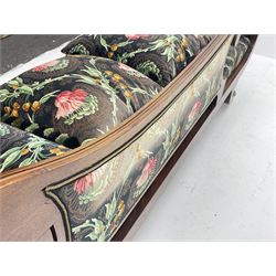 Regency period mahogany chaise longue, the moulded frame with scrolling terminals, splayed supports with cast brass hairy paw castors, upholstered in dark ground fabric with floral and foliate pattern, complimentary scatter and baluster cushions