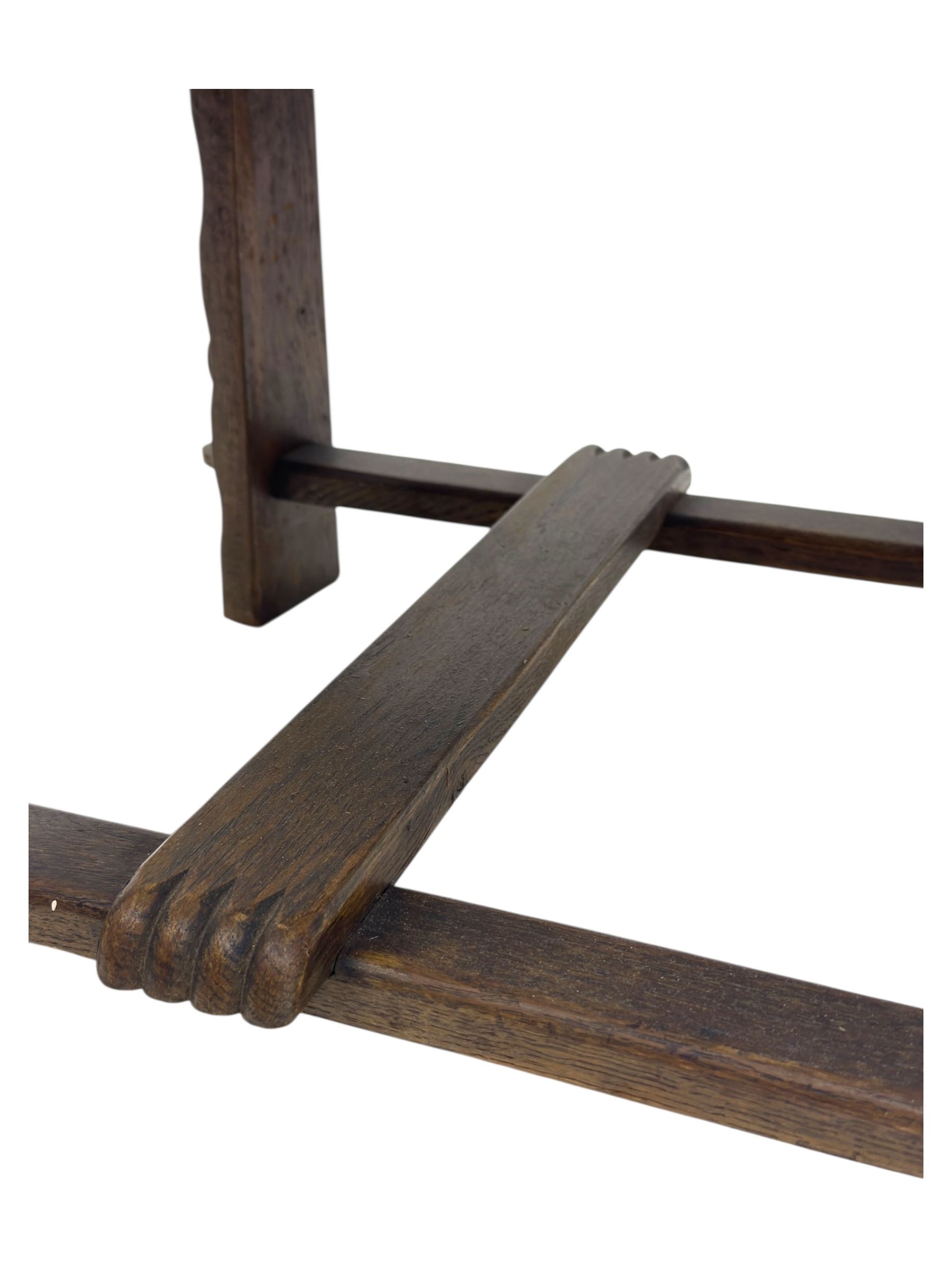 Pair of Arts and Crafts oak armchairs each with shaped backrest centred by polychrome painted crest, rush seat over straight square legs united by shaped central stretcher